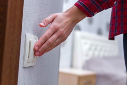 Someone switching a light off to save energy.